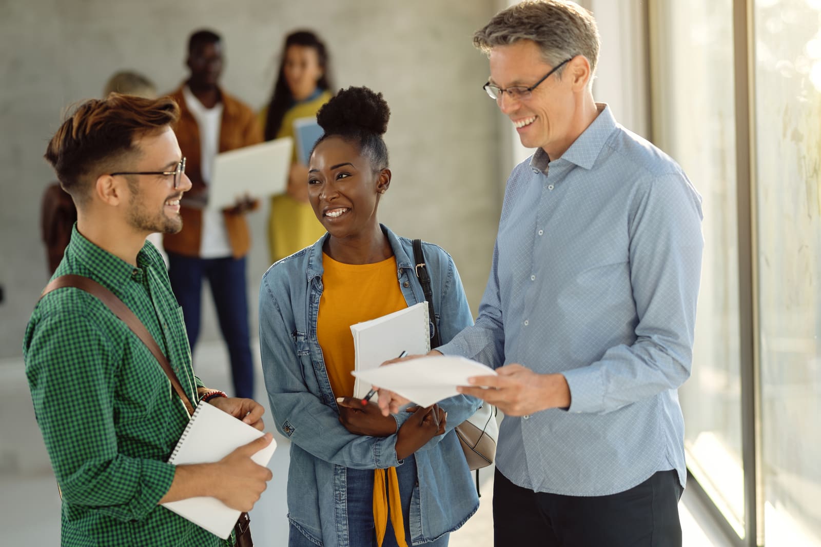 A postsecondary education administrator meeting with staff in a university office