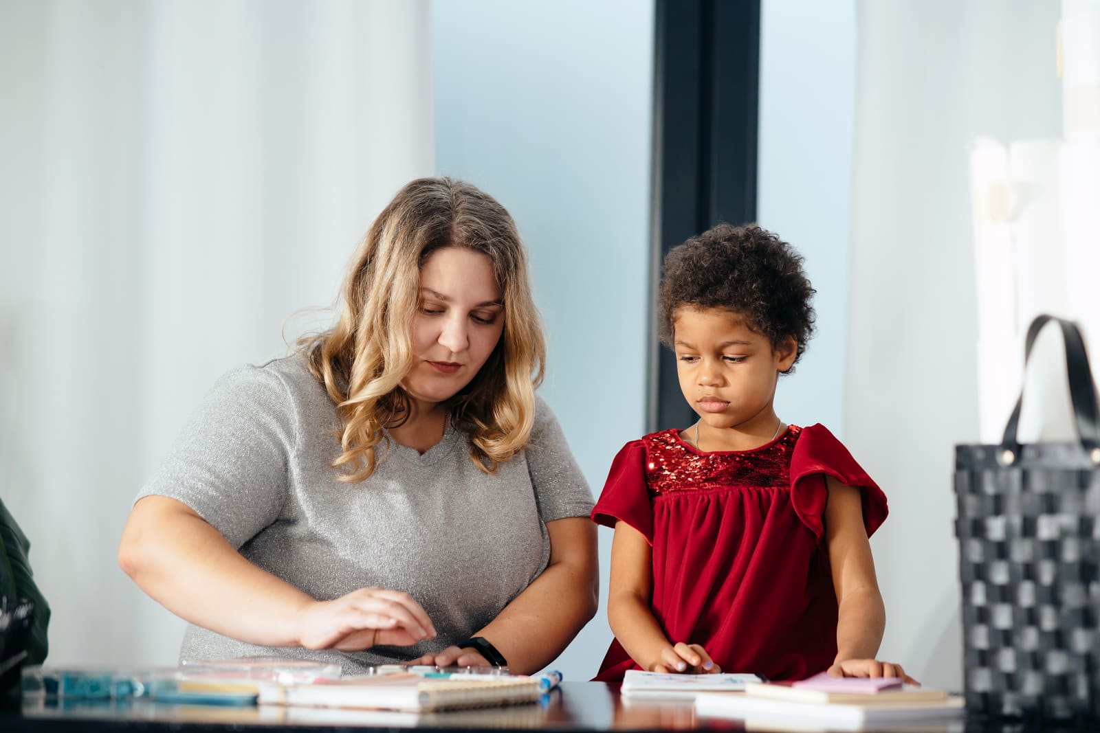 A teacher assistant helping students with their work in a classroom