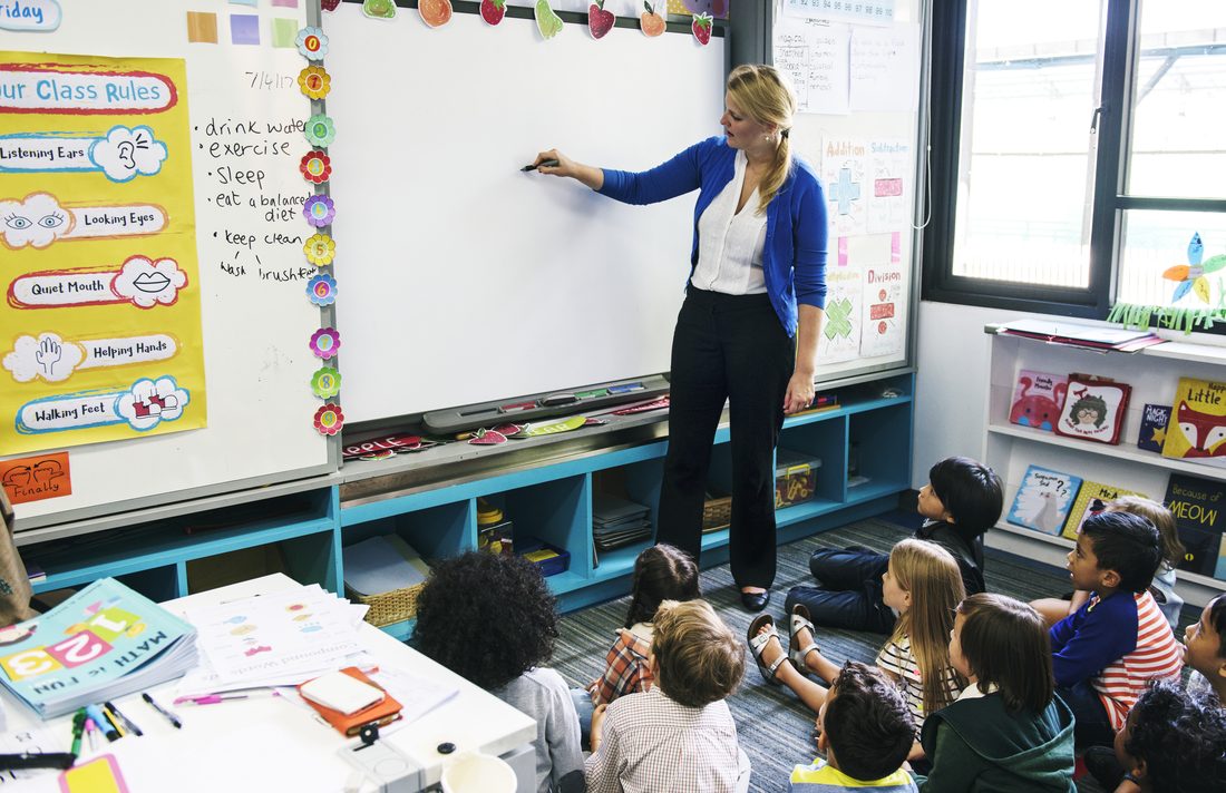 Happy elementary school children learning together in class