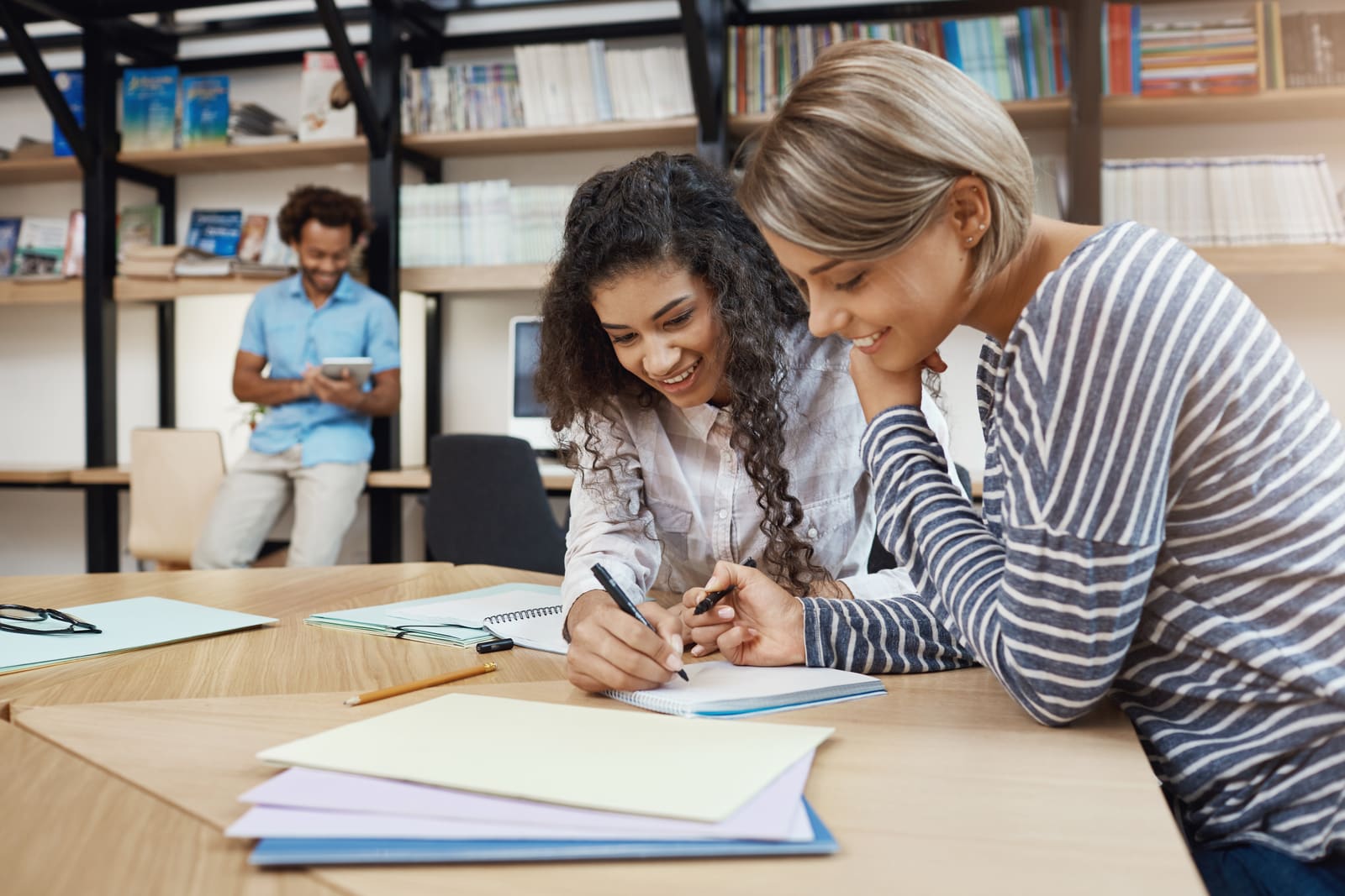 A middle school teacher working with early adolescent students at their desks