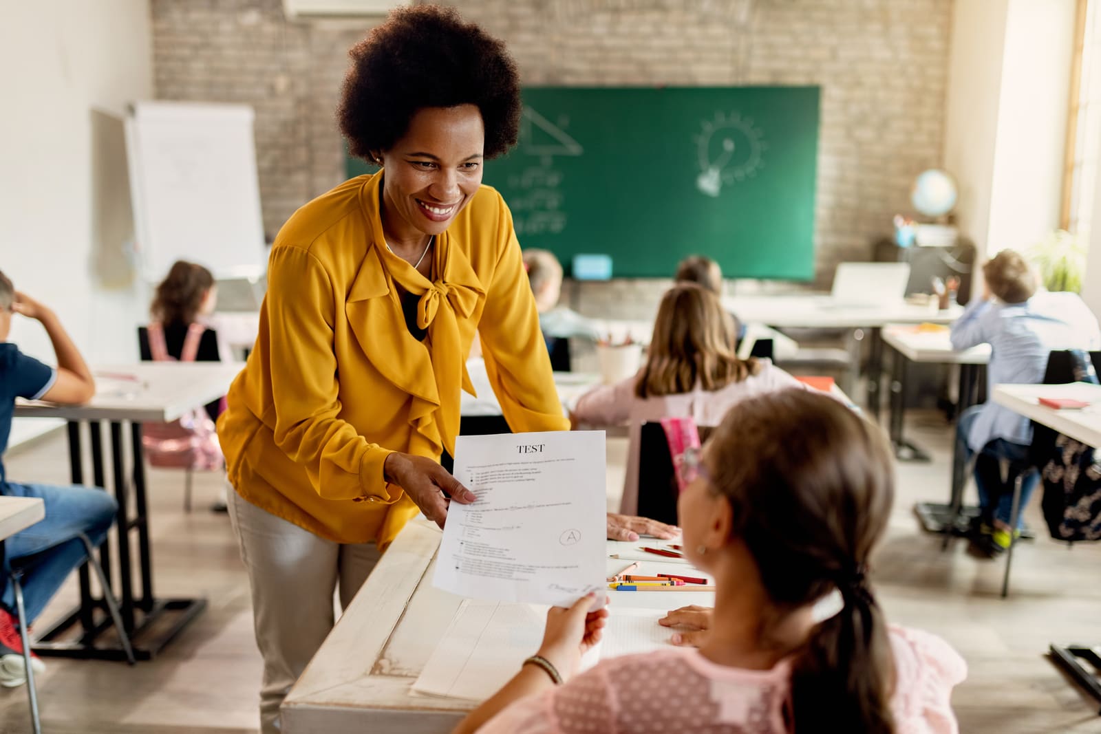 A middle school teacher working with early adolescent students at their desks