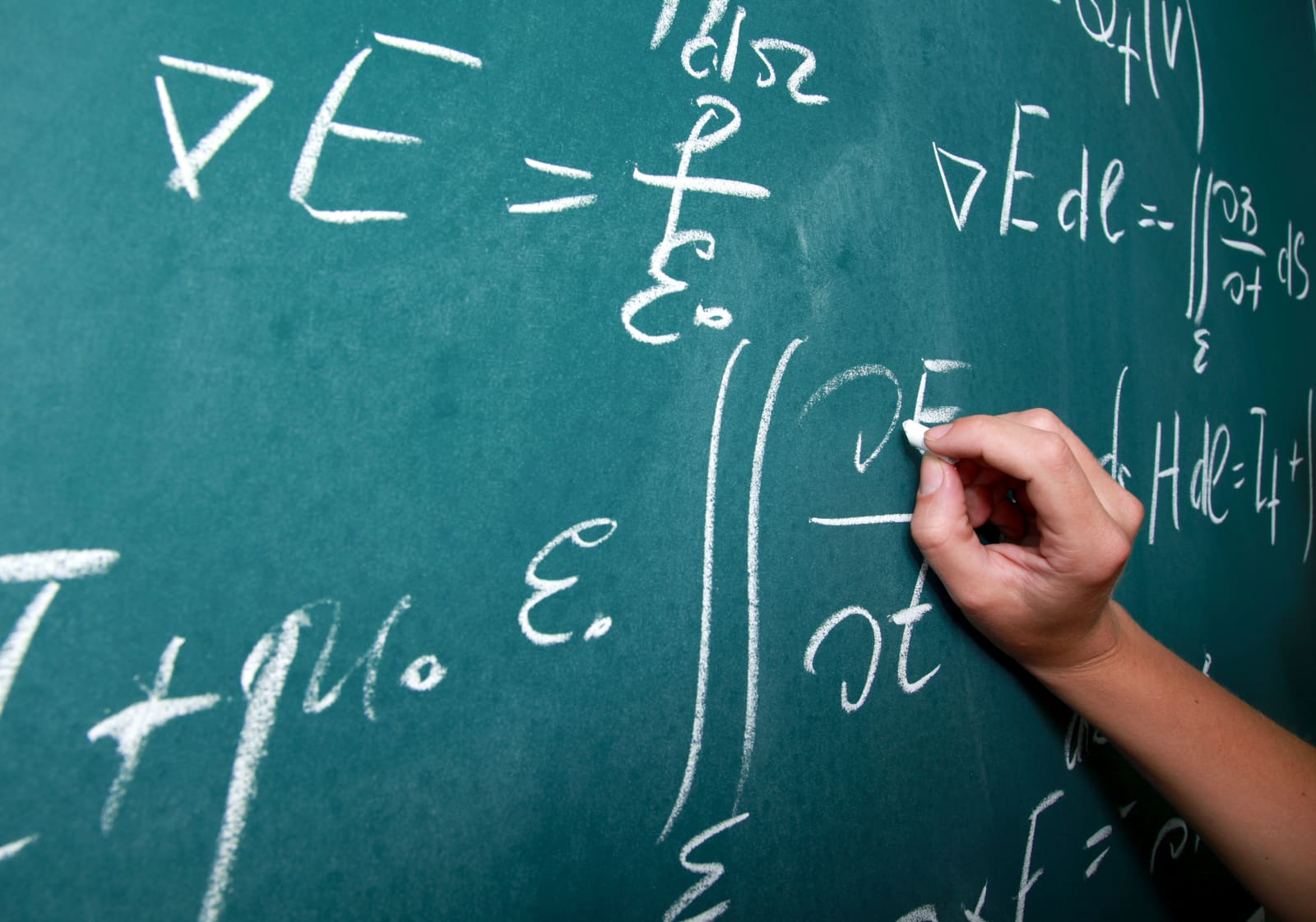 A mathematics teacher working through an equation on the whiteboard with students