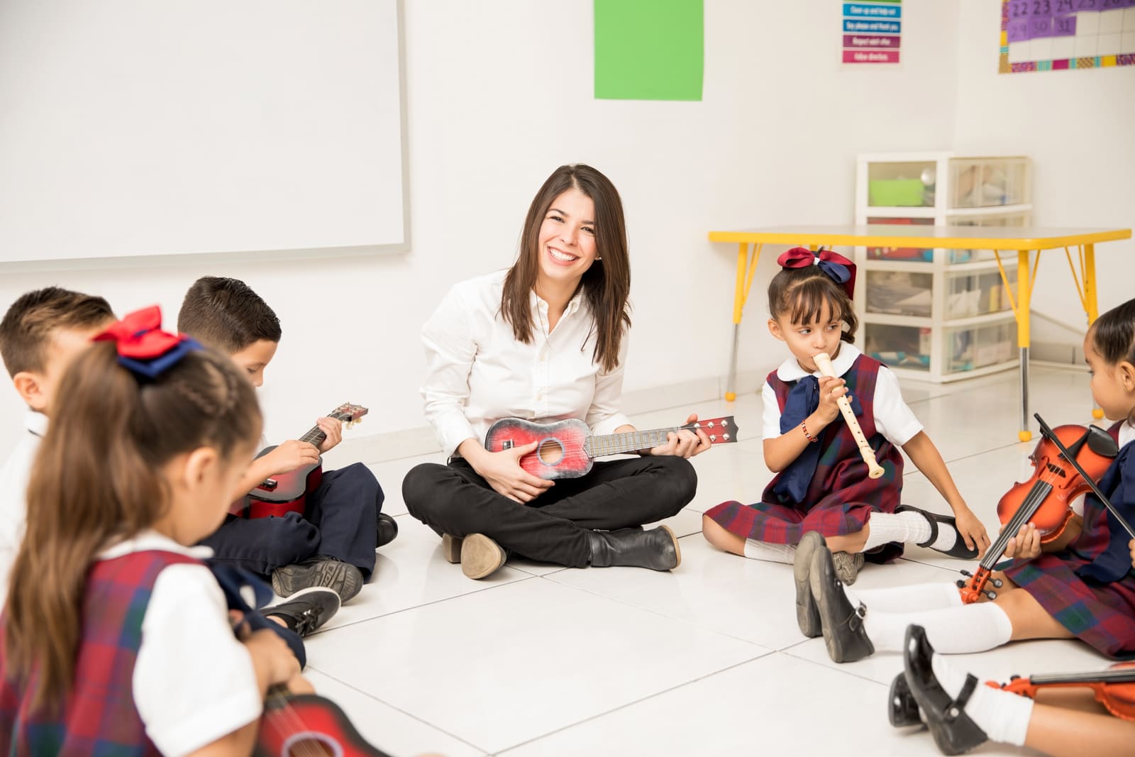 A music education teacher guiding a student reading sheet music at a keyboard