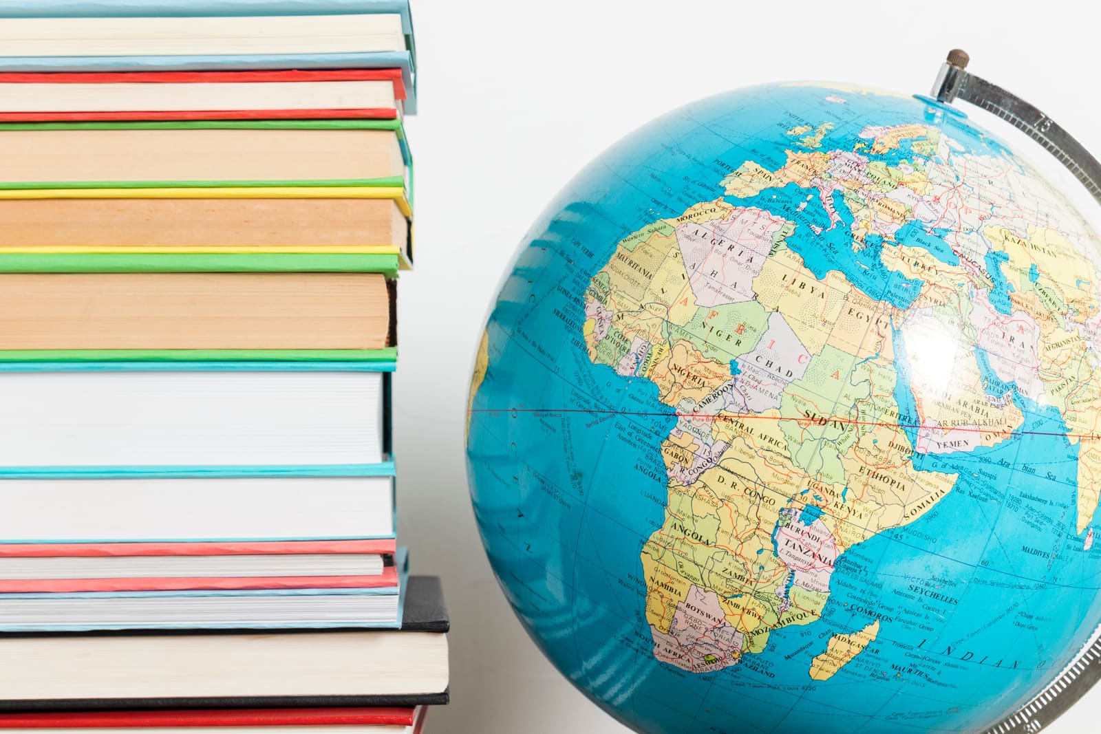 A social studies teacher pointing to a world map while teaching a class
