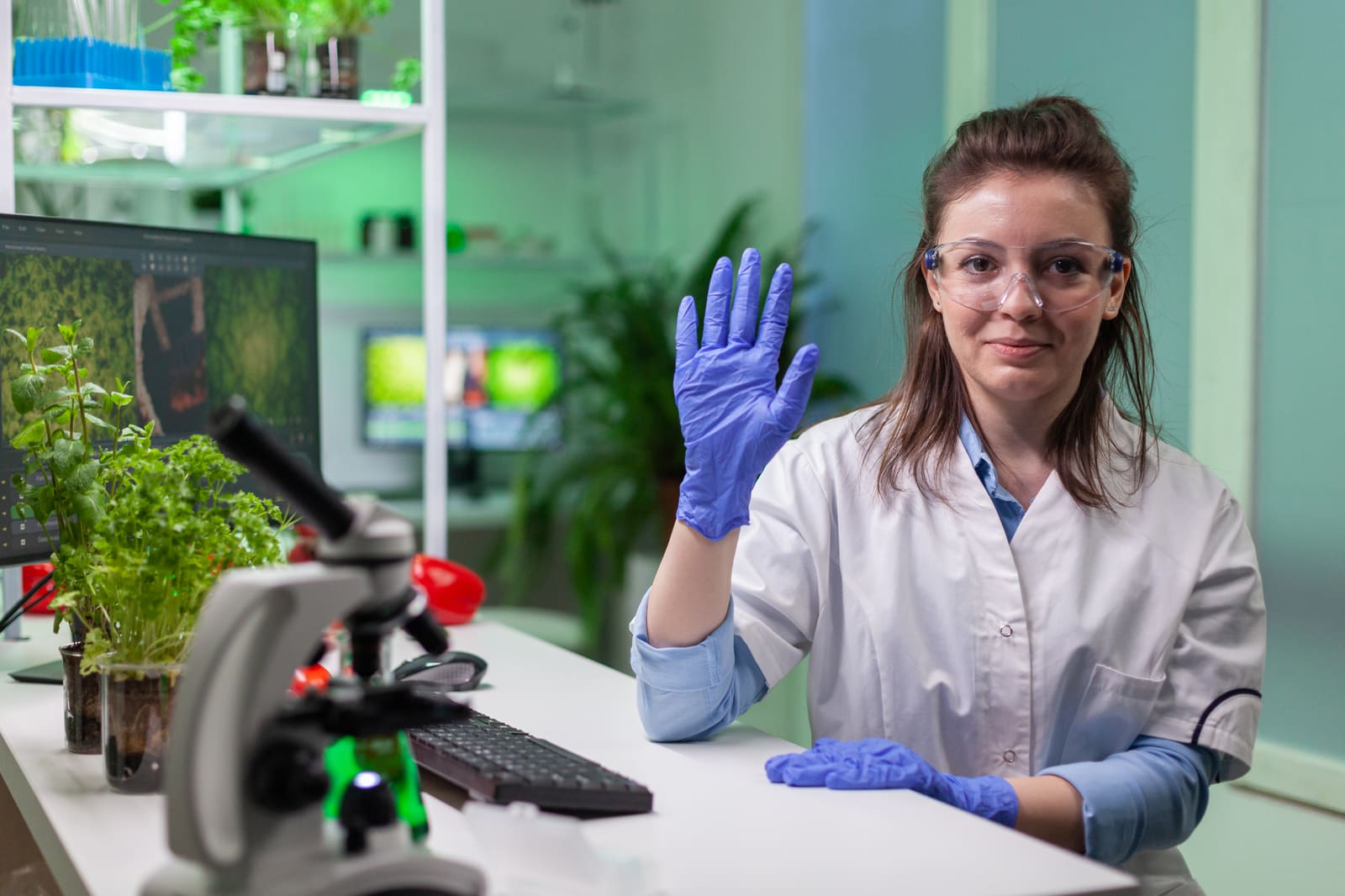 A biology teacher helping students examine specimens under microscopes in the lab