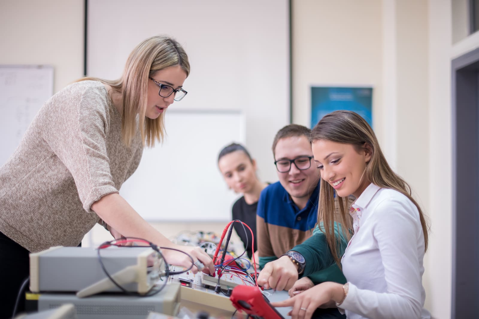 A career and technical education teacher demonstrating equipment to students in a lab