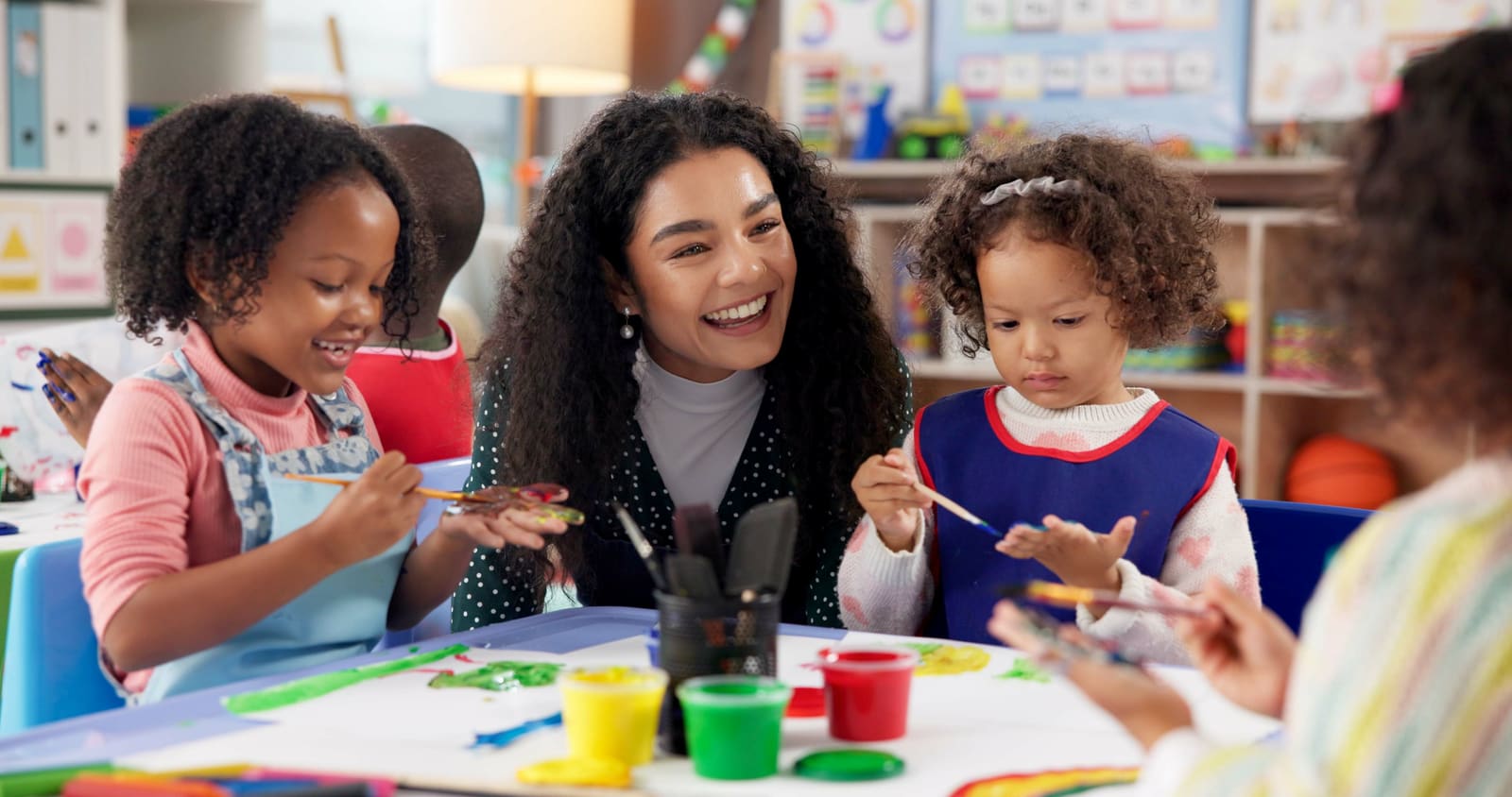 A kindergarten teacher leading a circle-time activity with kindergarten students