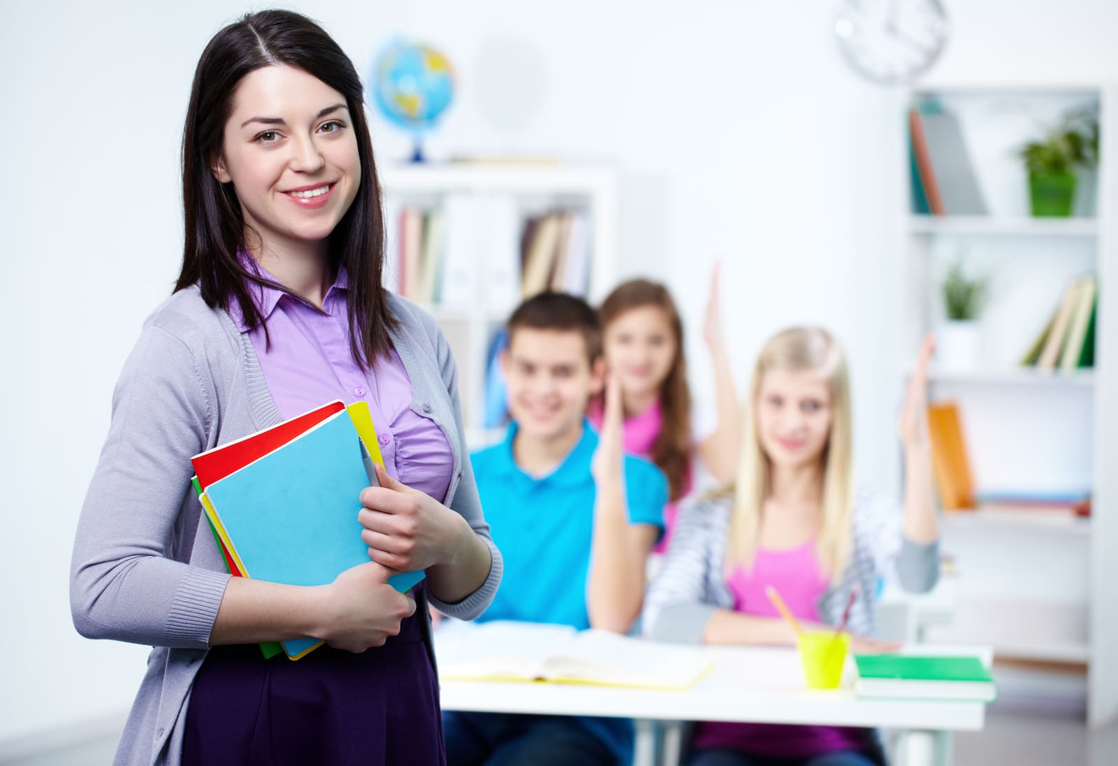 A middle school teacher leading a class discussion at the whiteboard