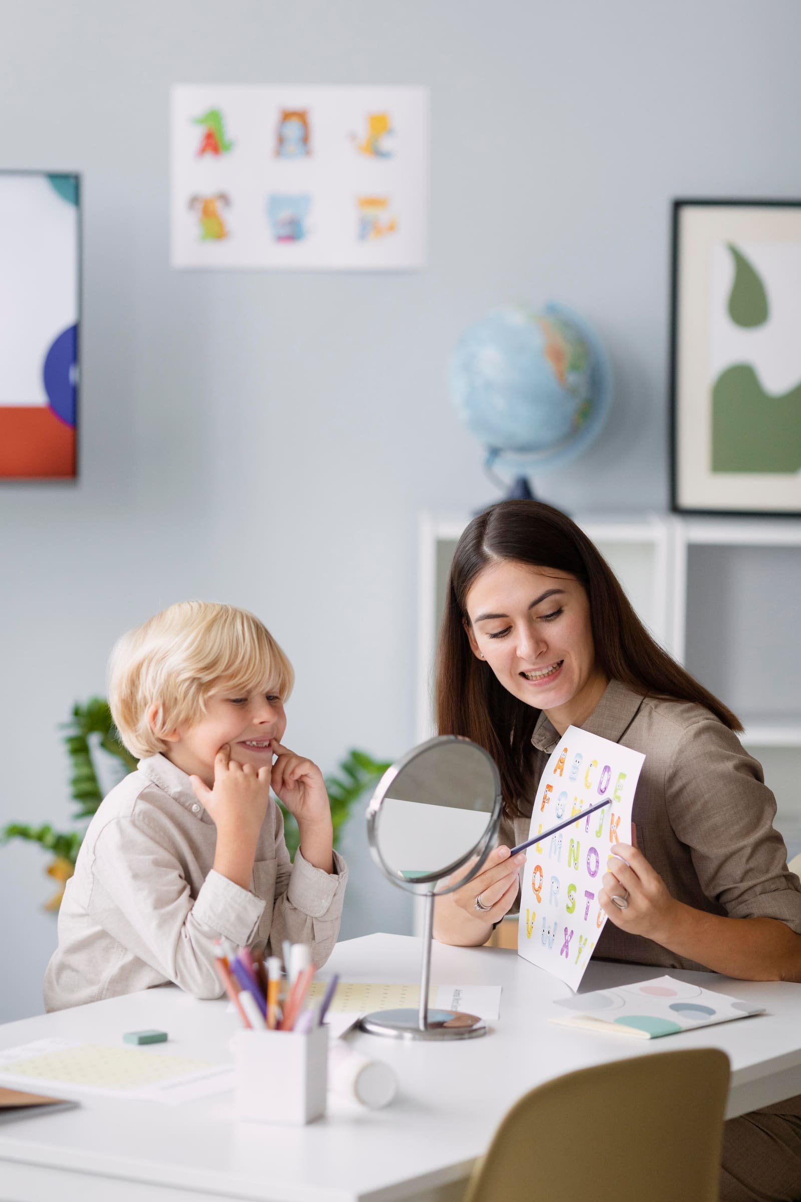 A teacher assistant supporting a small group of students at a table